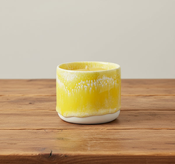 Bienenwachskerzen im gelben Keramikbecher auf dem Tisch