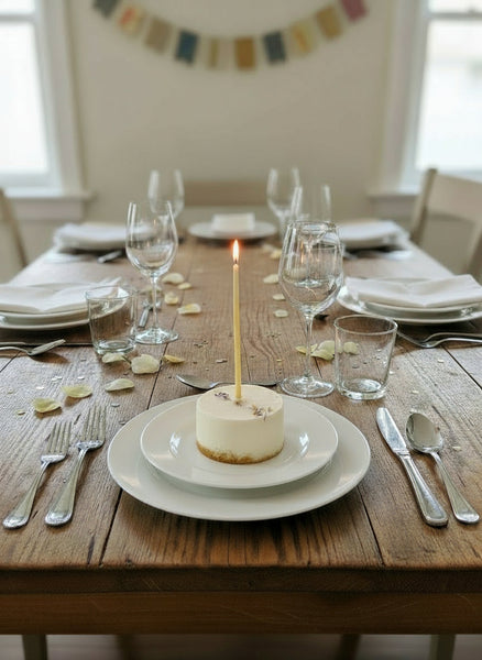 Geburtstagskerzen aus Bienenwachs im Geburtstagskuchen auf einem gedeckten Tisch